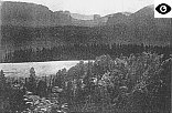 Photo einer Landschaft mit Bergen und Wälden